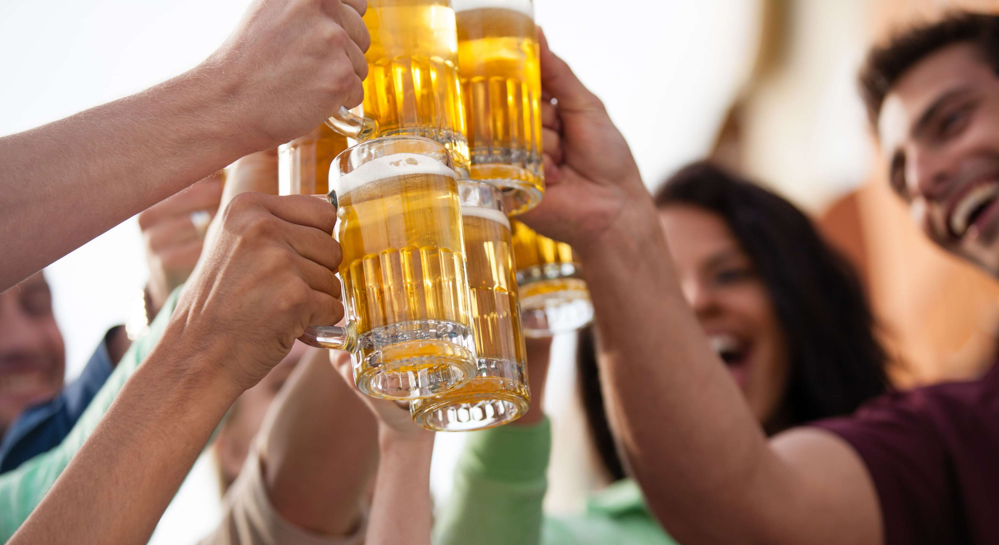 Allianz Gesundheitswelt - Check Alkoholkonsum: Eine Gruppe junger menschen stößt mit Bierkrügen an.