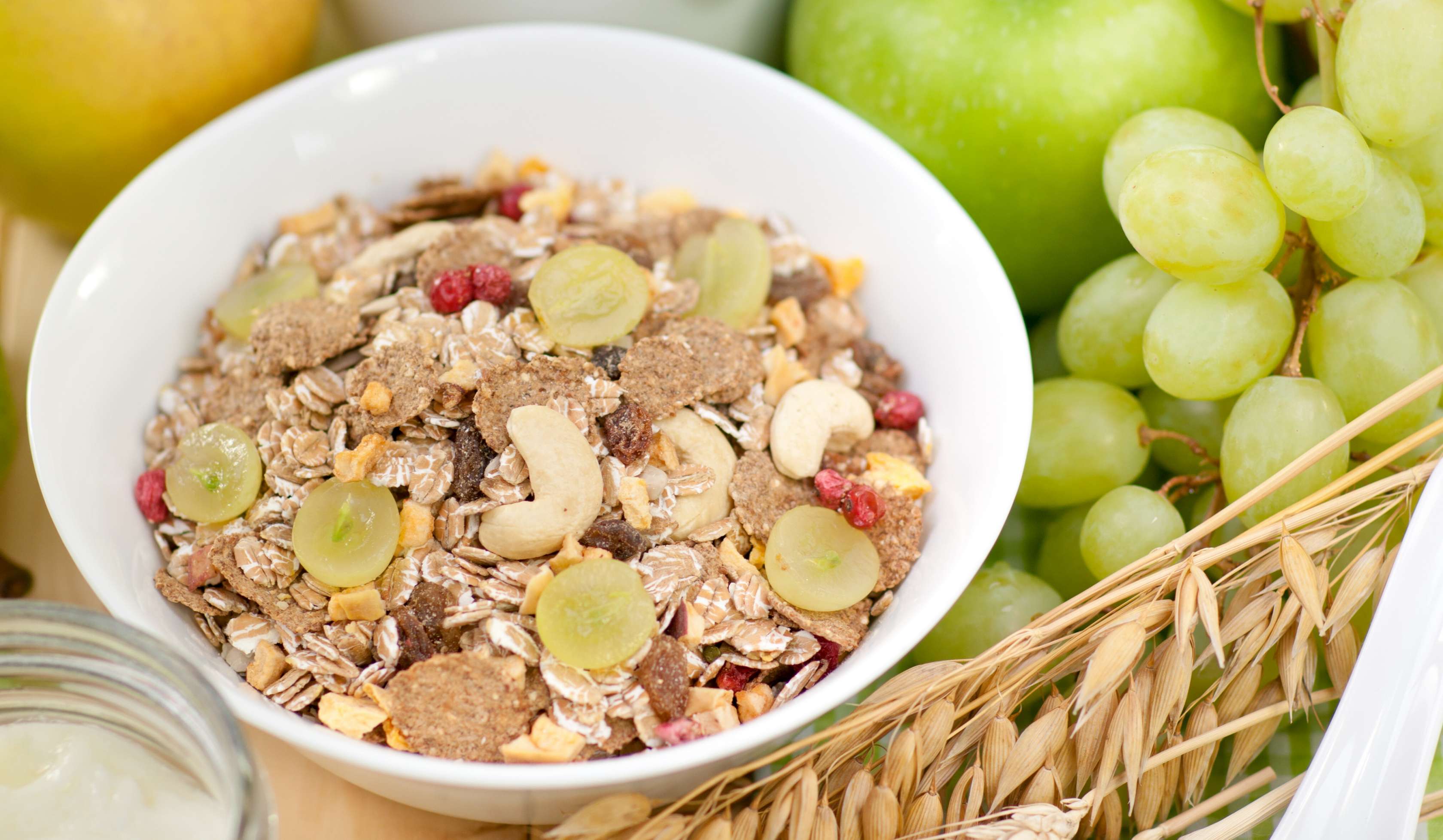 Allianz Gesundheitswelt - Ernährung als Schutzfaktor: eine Müslischale  steht auf einer Holzunterlage. Drum herum ist obst verteilt.