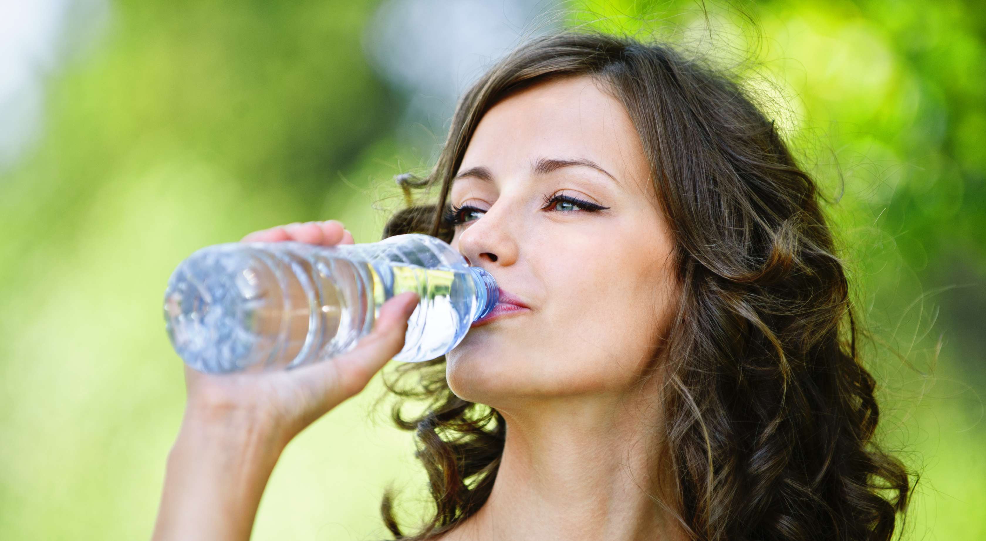 Allianz Gesundheitswelt - richtig Trinken Fakten: Eine junge Frau trinkt Wasser aus einer Plastikflasche.