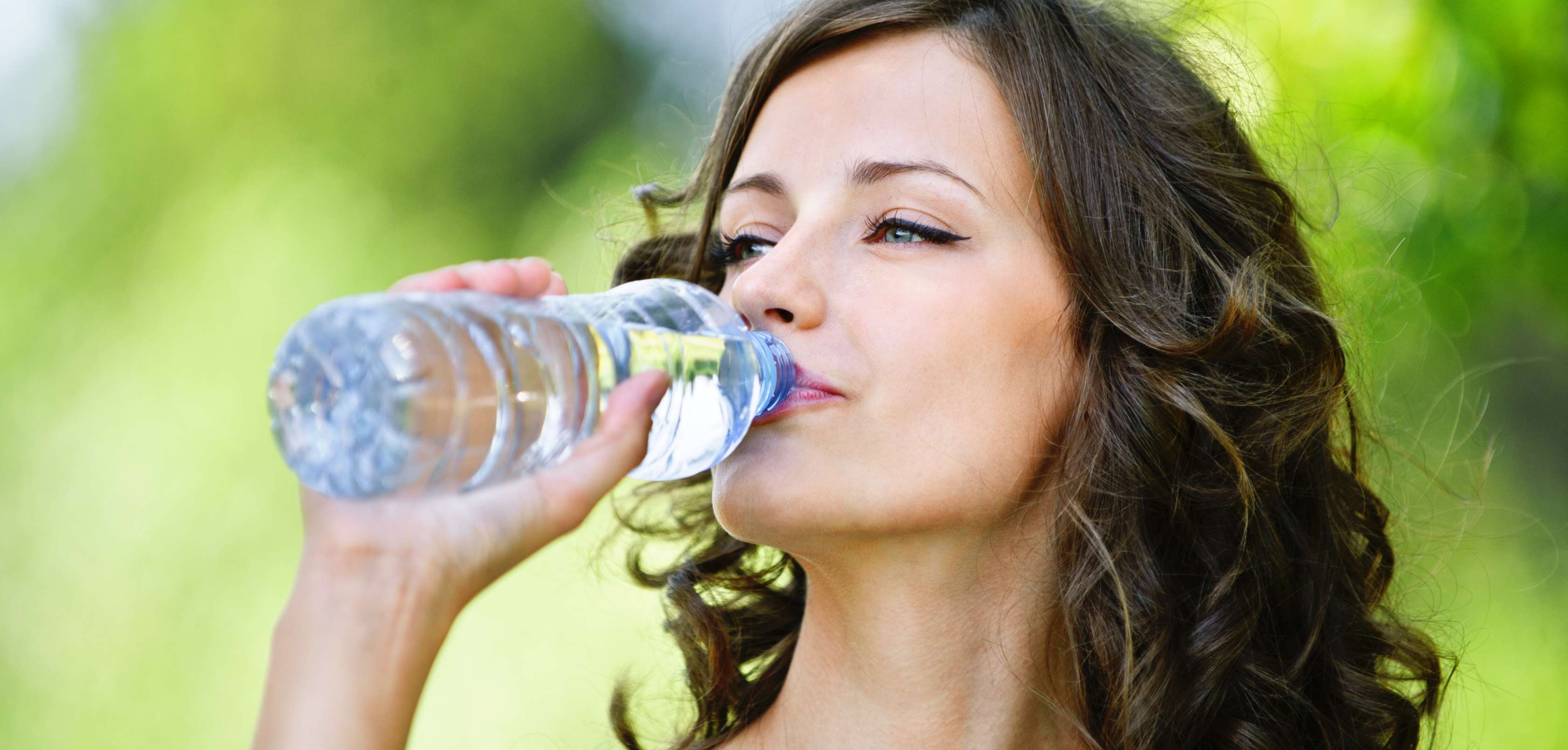 Allianz Gesundheitswelt - richtig trinken: eine Frau trinkt aus einer Plastikwasserflasche.