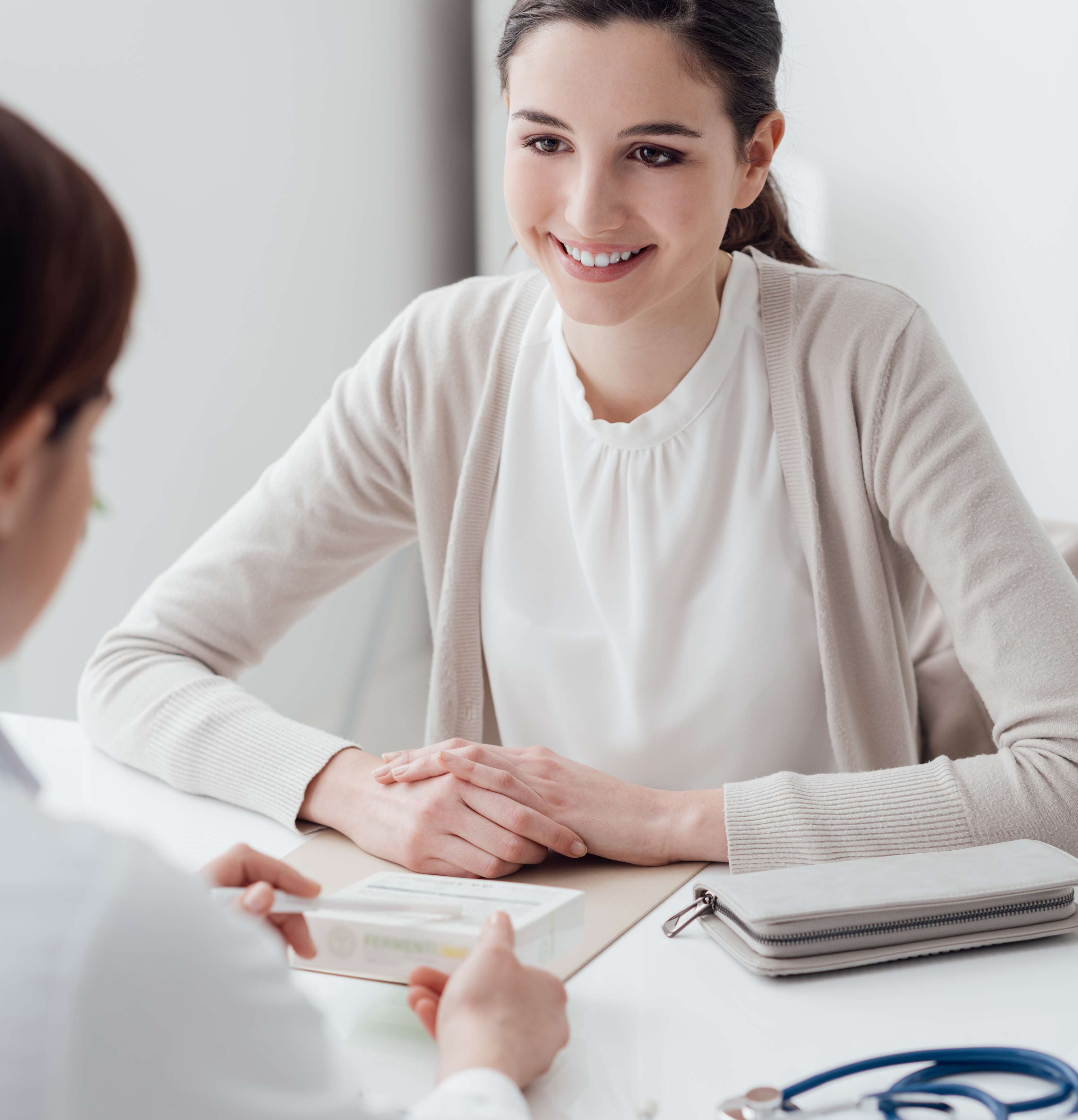 Brustkrebs-Warnsignale: Eine junge Frau bespricht sich mit Ihrer Frauenärztin.