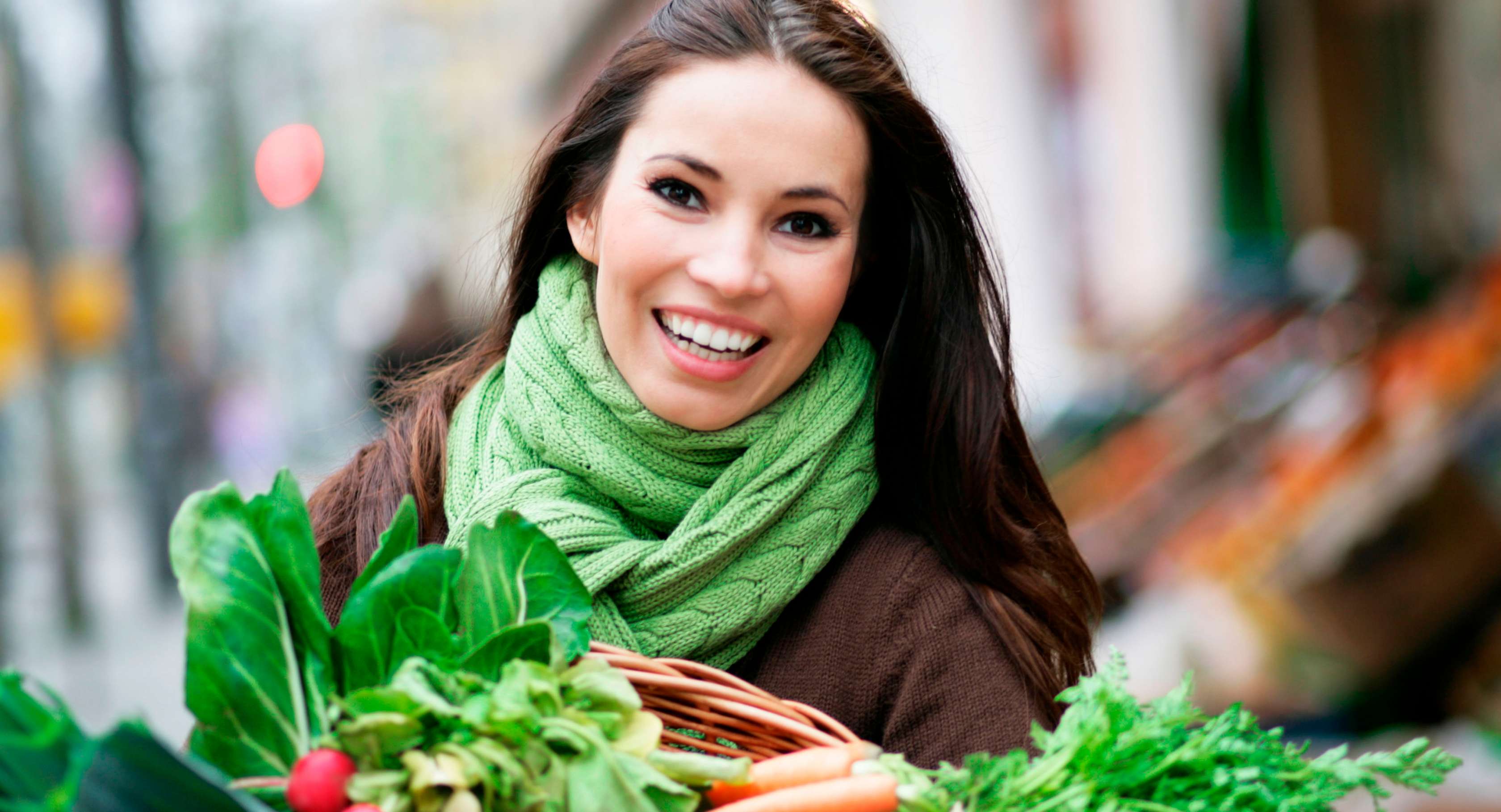 Allianz Gesundheitswelt - Vitamin C: Eine Frau mit langen dunkelen Haaren lacht in die Kamera.