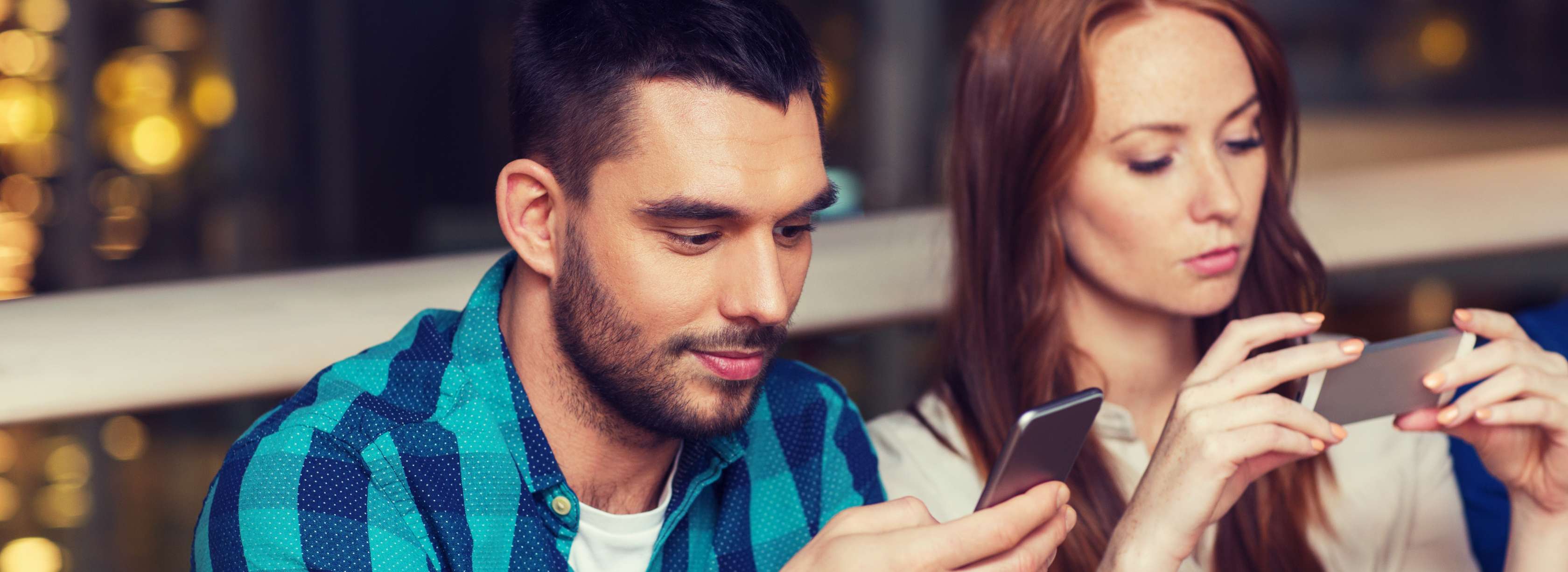 Allianz Gesundheitswelt - Beziehungskiller Smartphone: Pärchen sitzt nebeneinander. Jeder sieht nur auf das jeweilige Smartphone