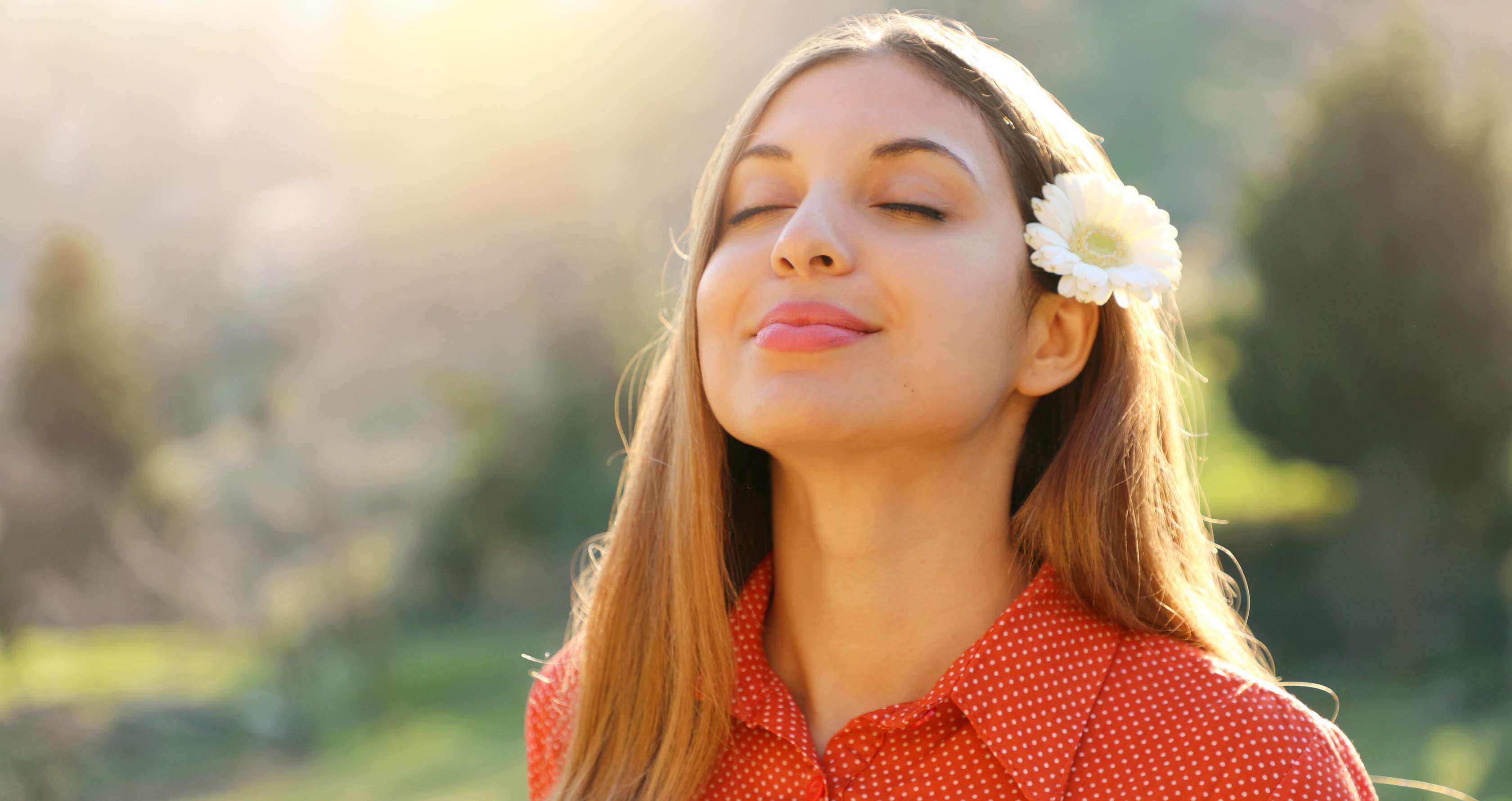 Allianz Gesundheitswelt - Frühlingsgefühle: Frau steht in der Natur und lacht
