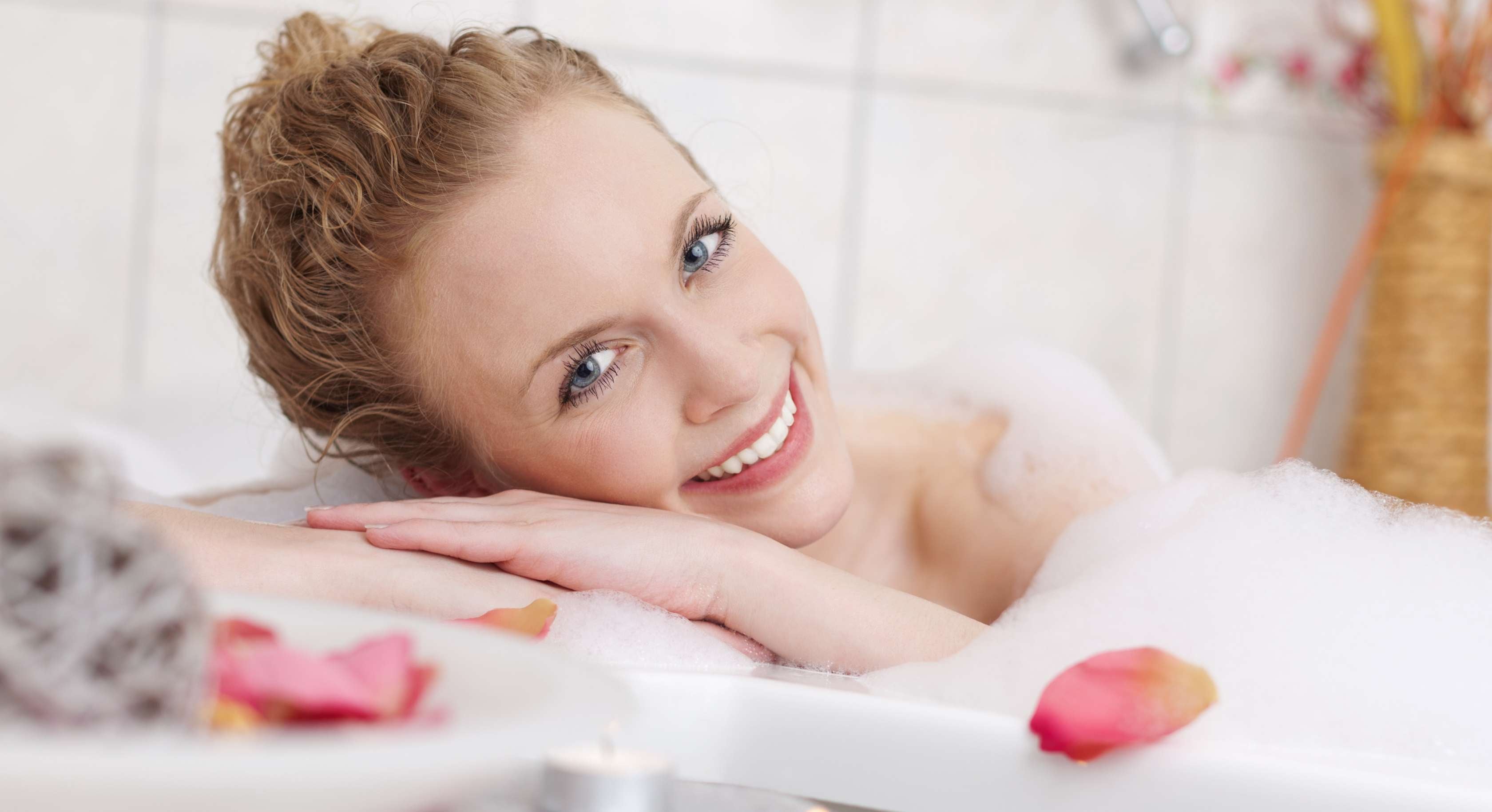 Allianz Gesundheitswelt - Winterdepression vorbeugen: Frau in Badewanne lächelt in die Kamera