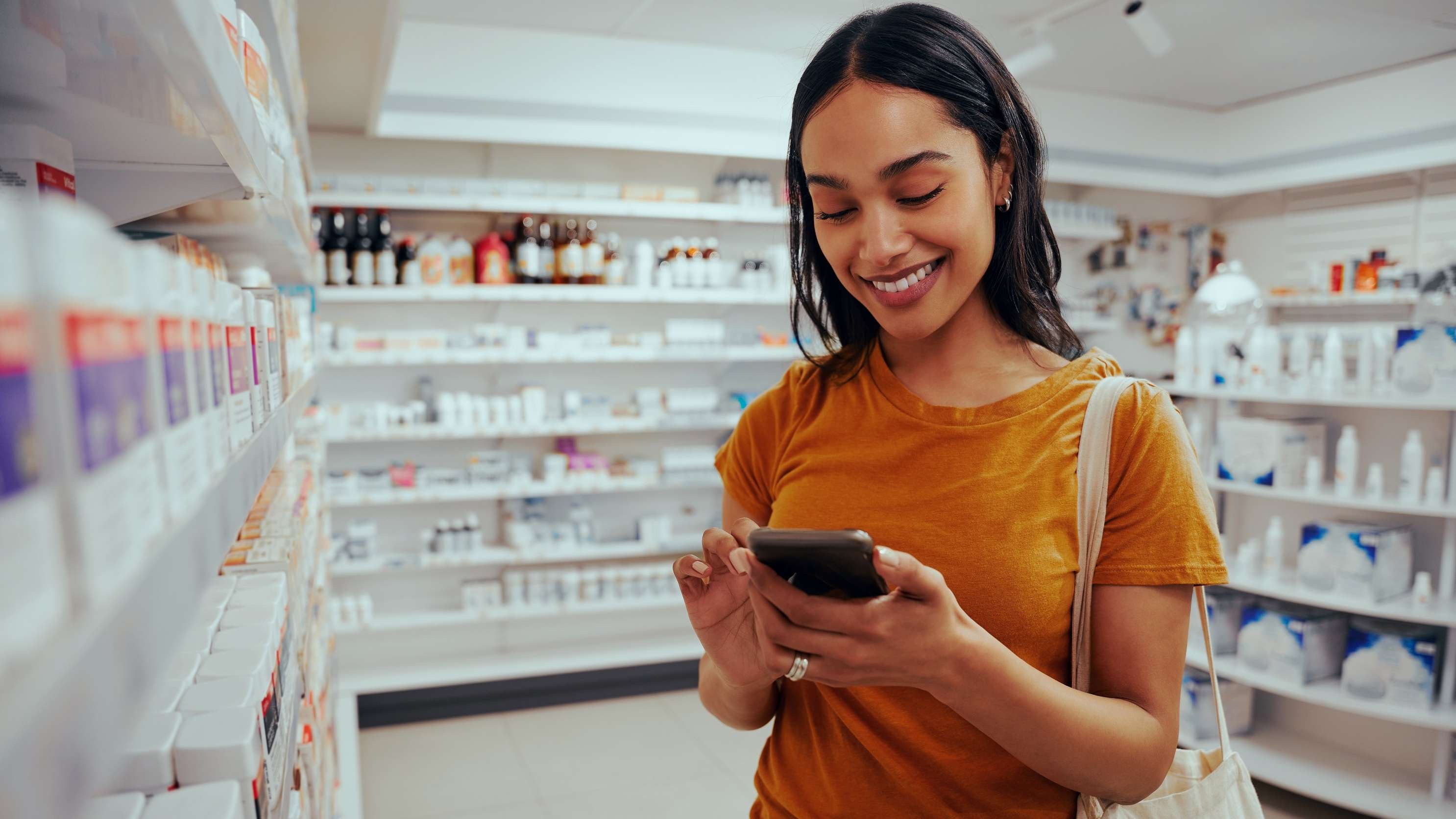 Allianz Gesundheitswelt - Das E-Rezept bei der Allianz Private Krankenversicherung: Eine Frau steht mit ihrem Smartphone in der Apotheke.