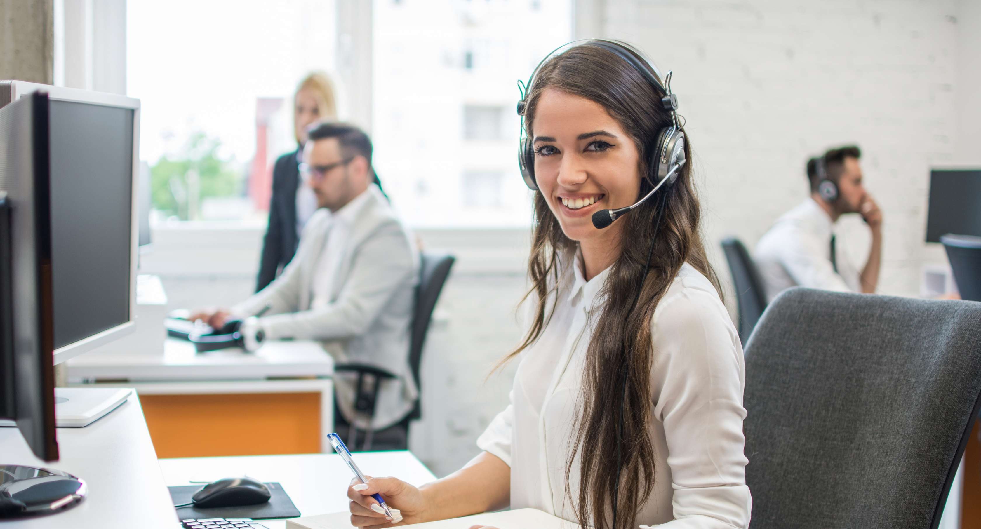 Allianz Gesundheitswelt - Patientenbegleiter der Allianz Private Krankenversicherung: eine junge Frau mit Headset sitzt an einem Schreibtisch.