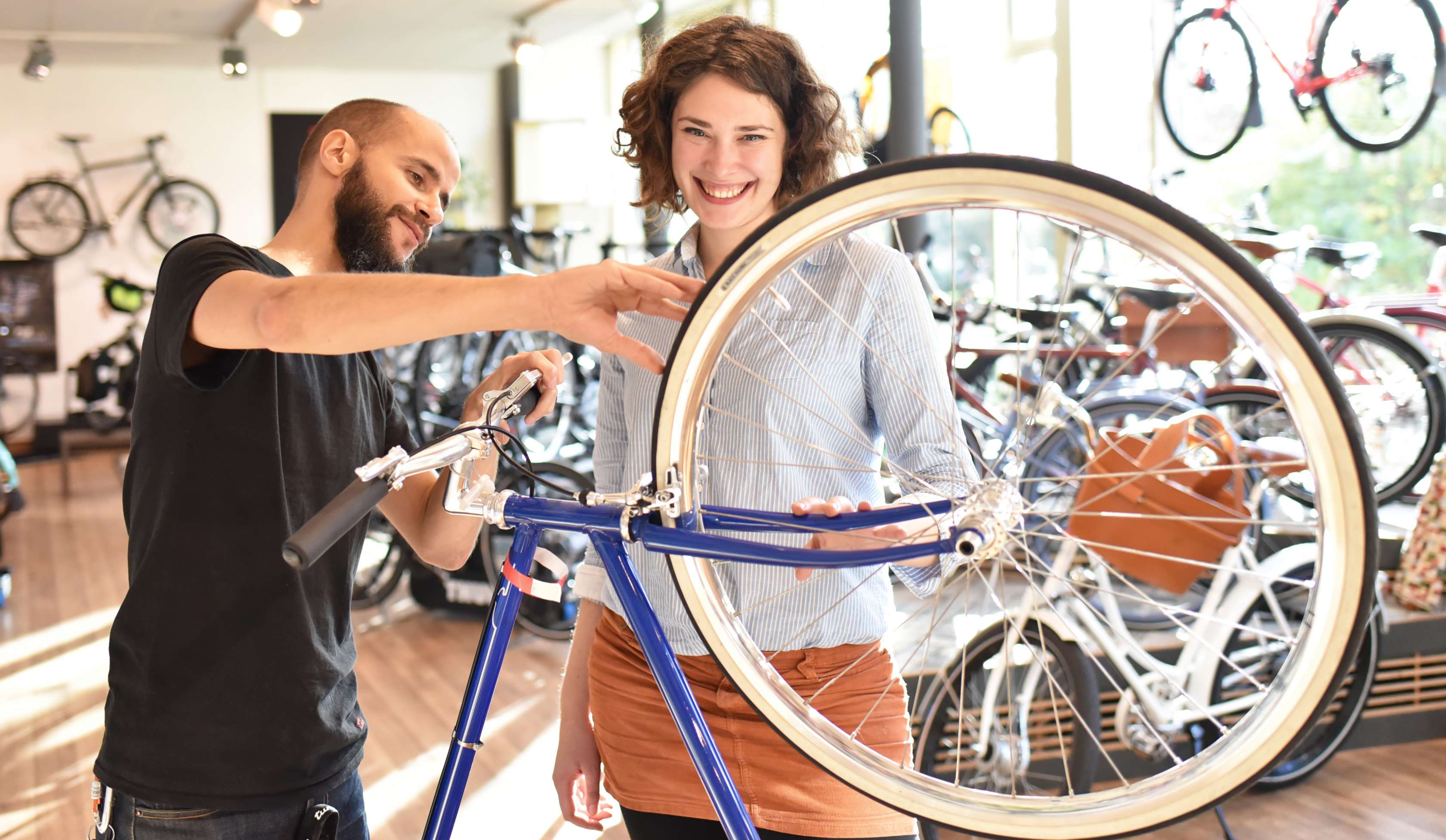 Allianz Gesundheitswelt - Tipps für den Fahrradkauf: Ein Verkäufer berät eine Frau bei der Auswahl des richtigen Rads.