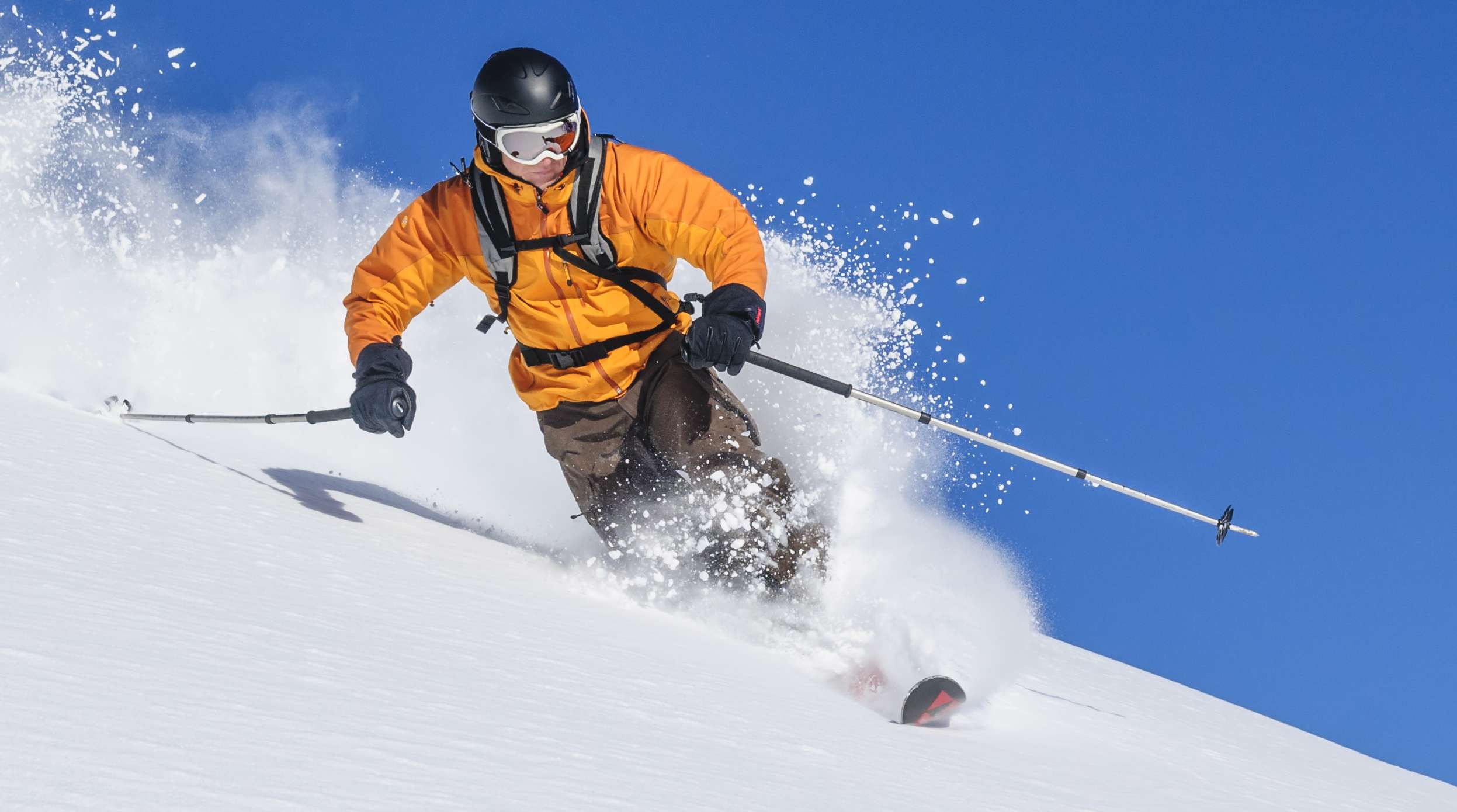 Allianz Gesundheitswelt - Skitypen: Ein Skifahrer mit Helm umd Skikleidung schwingt sich mit Skiern durch den Schnee.